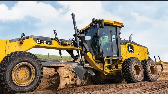 Grader with its blade down, levelling soil