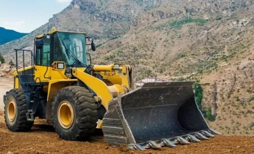 Wheel loader with its bucket lowered on a dirt site